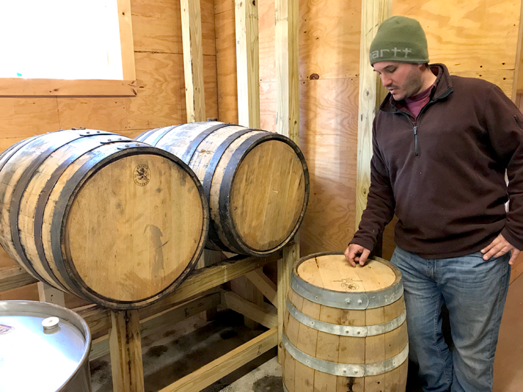 John Garigliano Next to Bourbon Barrels for Aging Syrup Catskill Mountain Sugar House